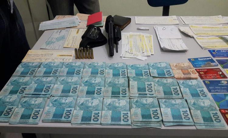 No cumprimento, a polícia encontrou cheques, R$ 24 mil em dinheiro, um revólver calibre 38 e cerca de 50 cartões de crédito e do Bolsa Família. 